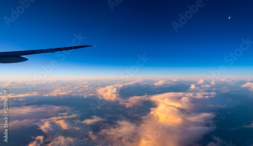 sunrise on clouds with moon from airplane