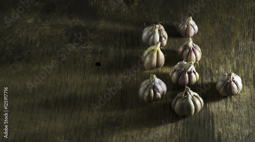 Heads of garlic on wooden background.
