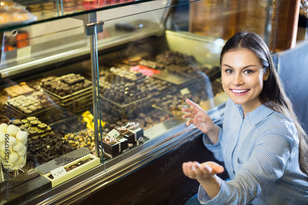 brunette girl buying dark and white chocolate with fillings