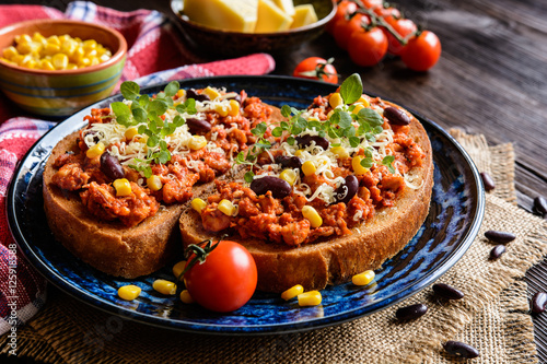 Fried toasts with chicken meat, tomato, chili, pepper, beans and