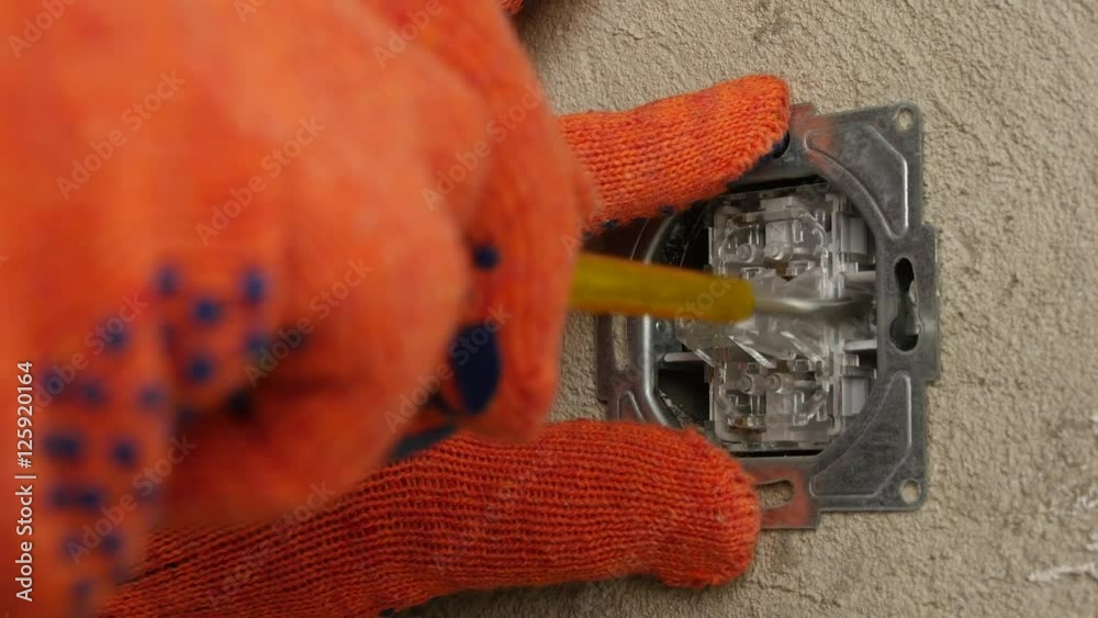 Electrician installing new light switch on wall