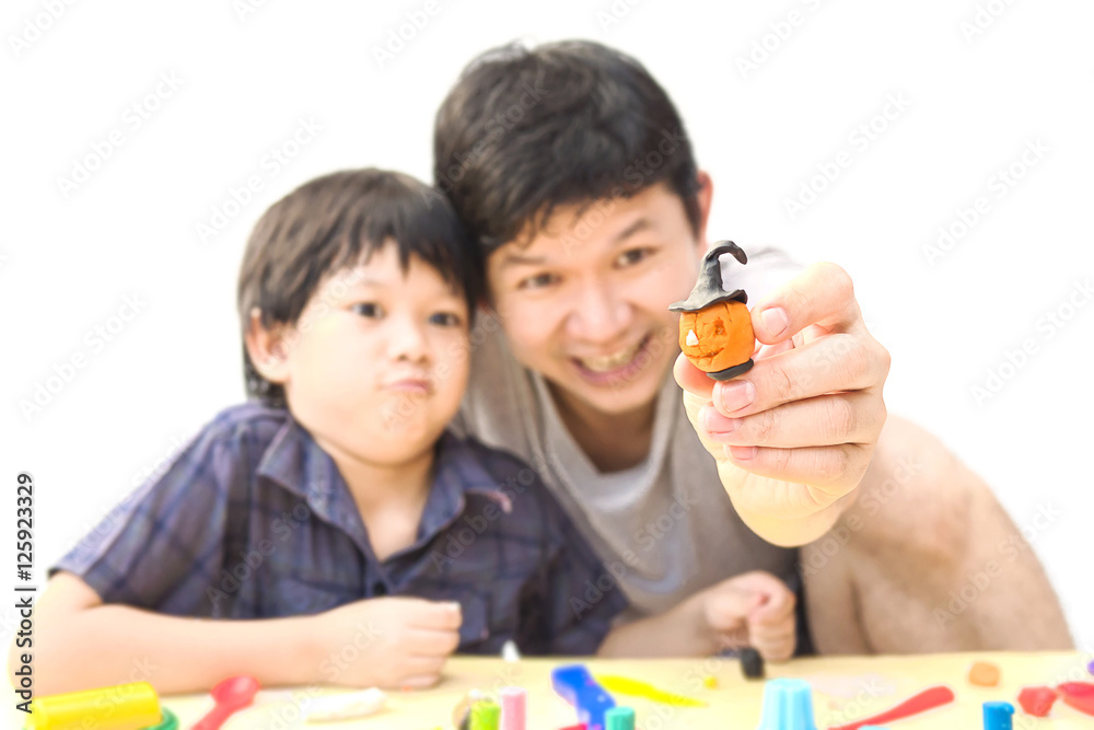 Father is playing Halloween clay with his son over white backgro Father is playing Halloween clay with his son over white backgro