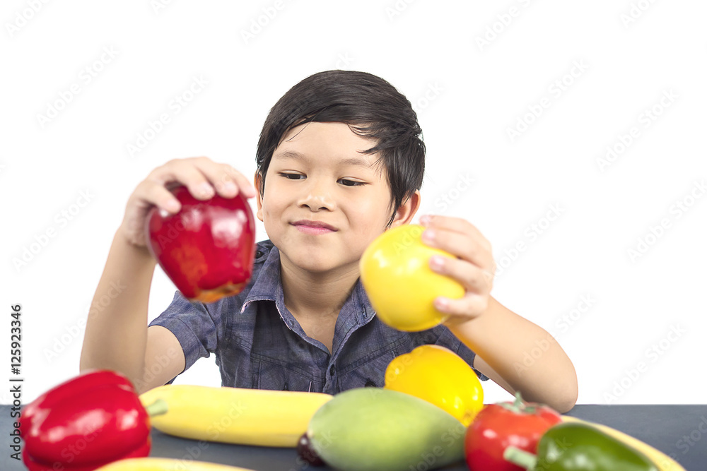 Fototapeta premium Asian healthy boy showing happy expression with variety colorful fruit and vegetable over white background