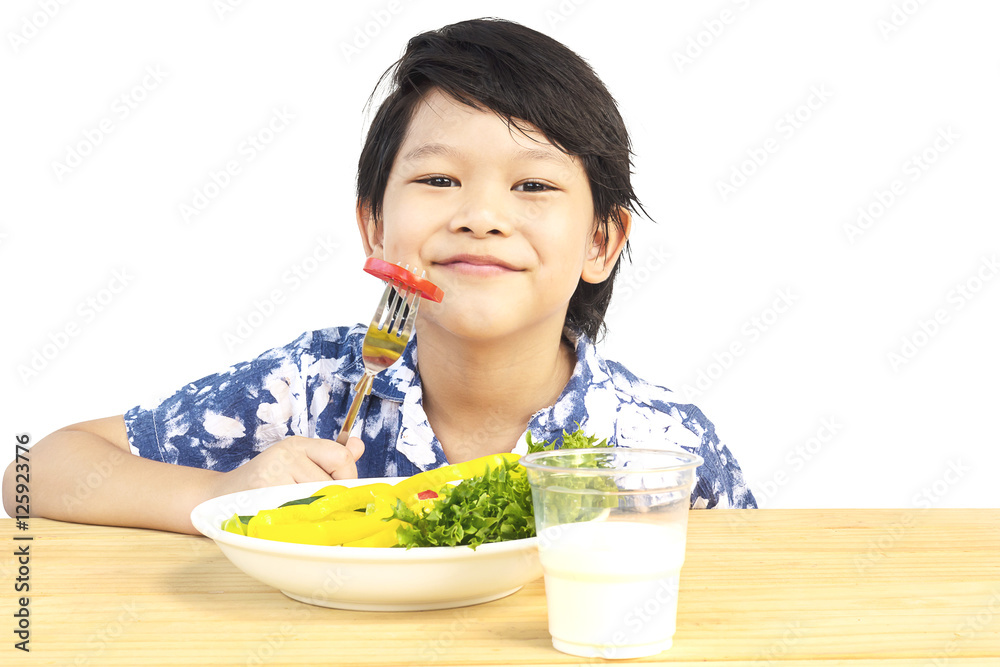 Asian lovely boy showing enjoy expression with fresh colorful vegetables and glass of milk isolated over white background Asian lovely boy showing enjoy expression with fresh colorful vegetables and glass of milk isolated over white background