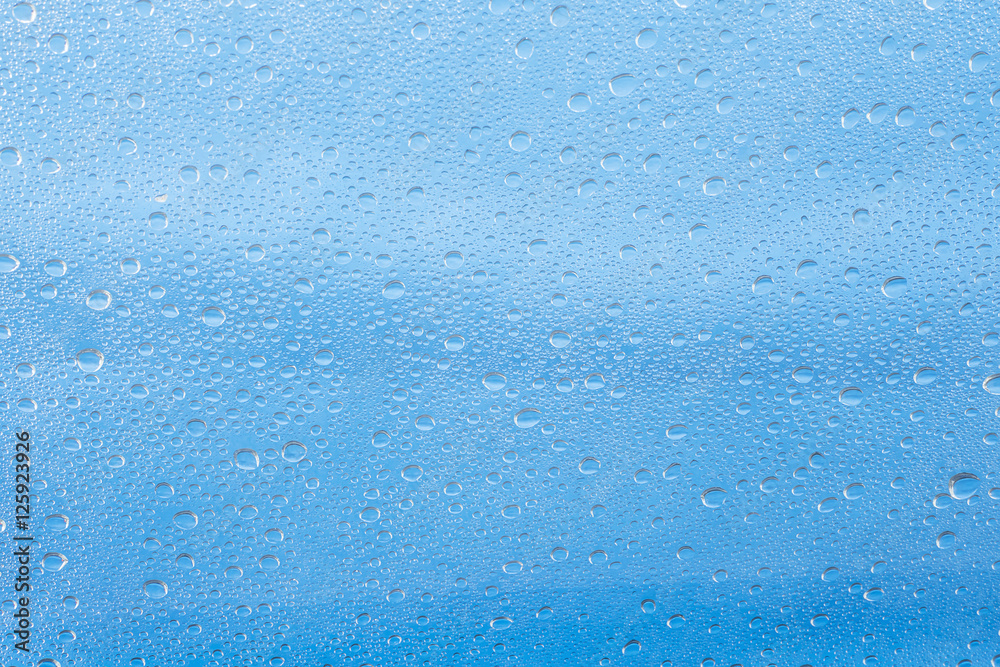 Obraz premium Rain drop on at glass window over blue sky background