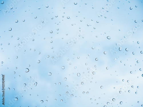 Rain drop stick at glass window over blue sky background