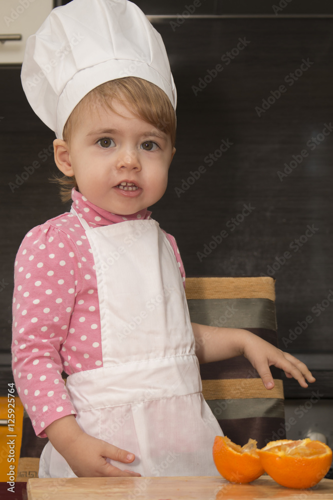 clouse-up portrait smile little cute girl in chef suit. Mother's helper. 2 year old. clouse-up portrait smile little cute girl in chef suit. Mother's helper. 2 year old.