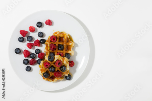 Waffles with berries and maple syrup