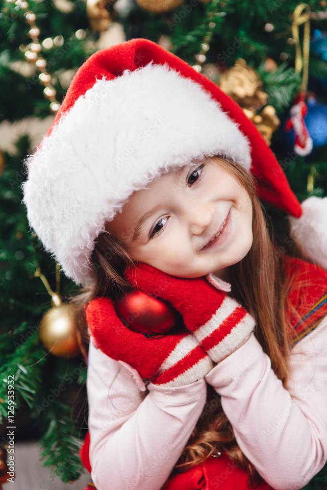 Smile girl in red hat hold a tree decoration Smile girl in red hat hold a tree decoration