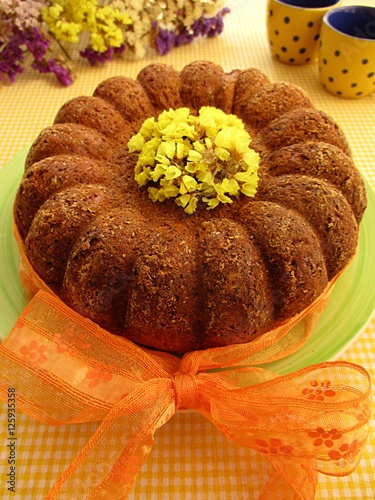 Kuglof with yellow flowers and orange bow photo