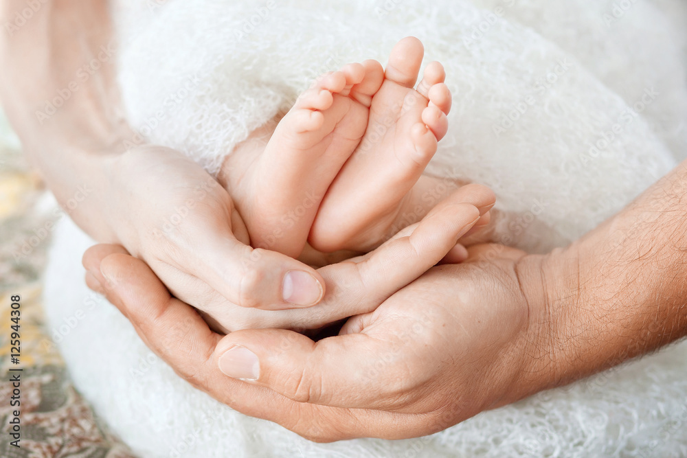 Baby feet in parents hands. Tiny Newborn Baby's feet on parents Baby feet in parents hands. Tiny Newborn Baby's feet on parents