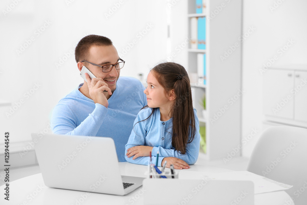 Daughter helping father working in office Daughter helping father working in office