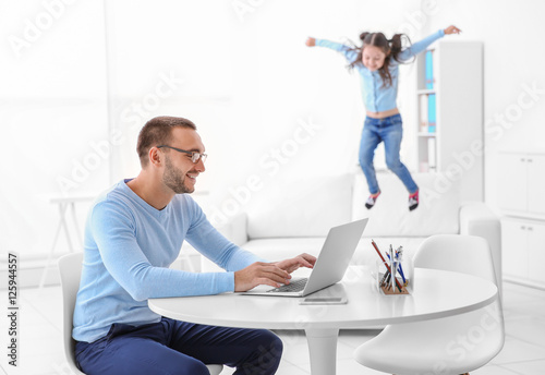Father working while his da...