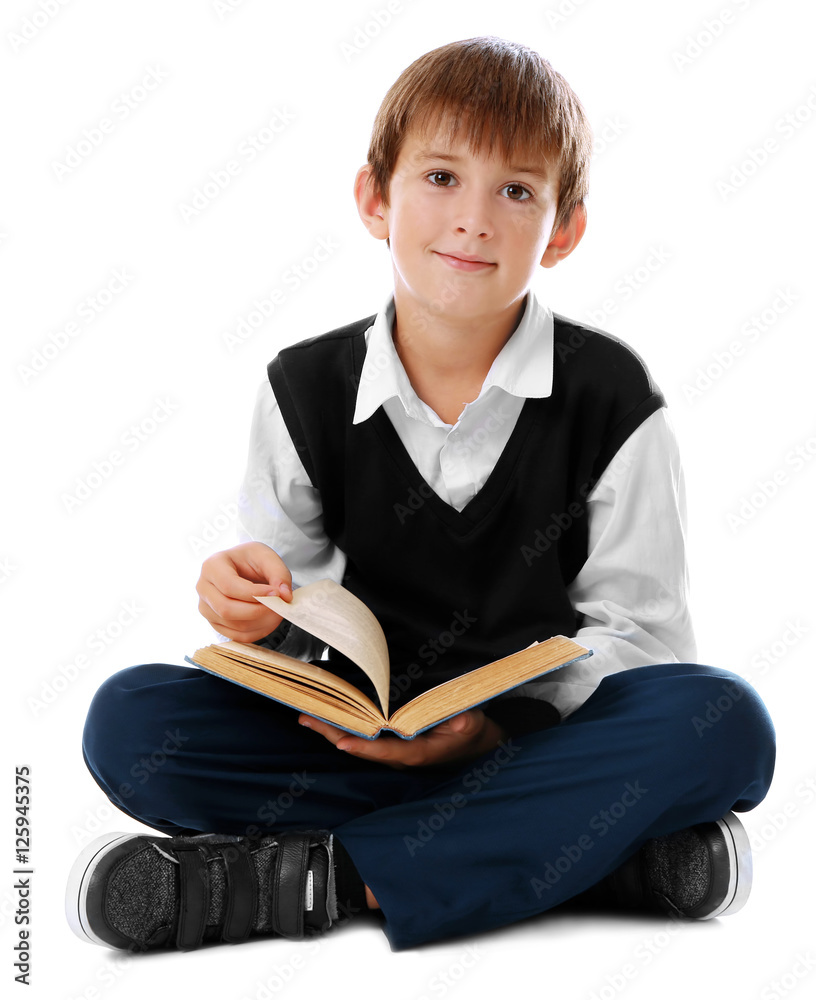 Cute schoolboy sitting with book on white background Cute schoolboy sitting with book on white background