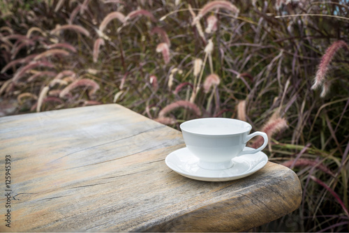 Coffee cup and tea On a Wooden table in the lawn garden.The visual style is warm Feeling relaxed