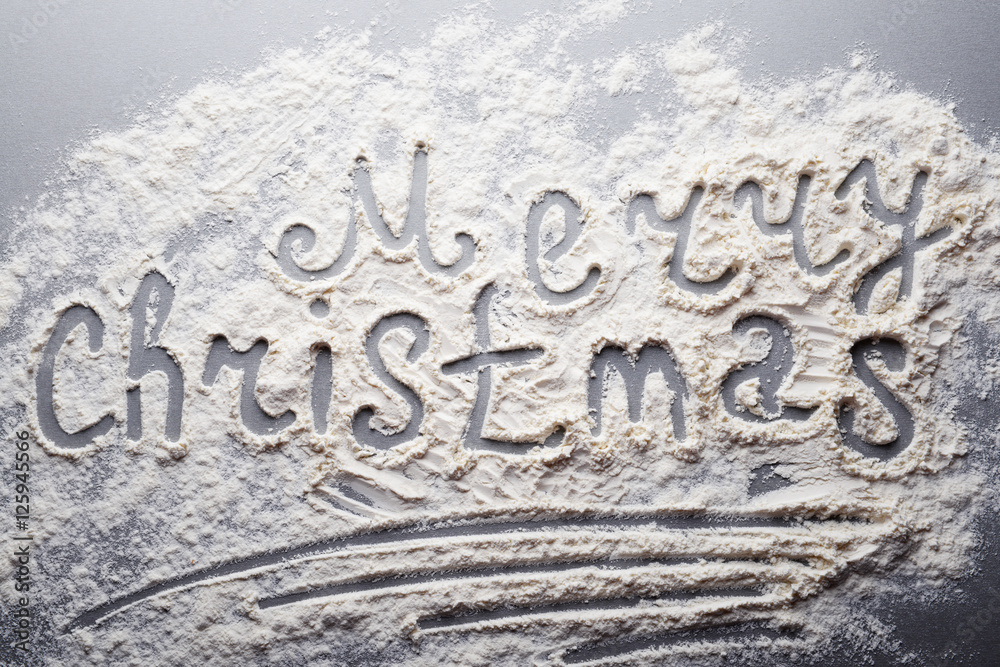 Inscription MERRY CHRISTMAS made with flour on grey table Inscription MERRY CHRISTMAS made with flour on grey table