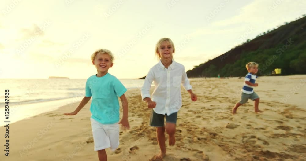 Happy family playing and having fun on the beach at sunset Happy family playing and having fun on the beach at sunset