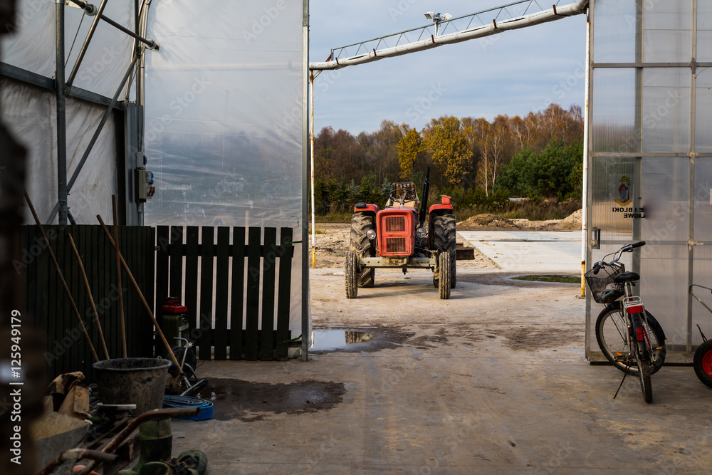 Obraz premium gospodarstwo szklarnia w tle traktor