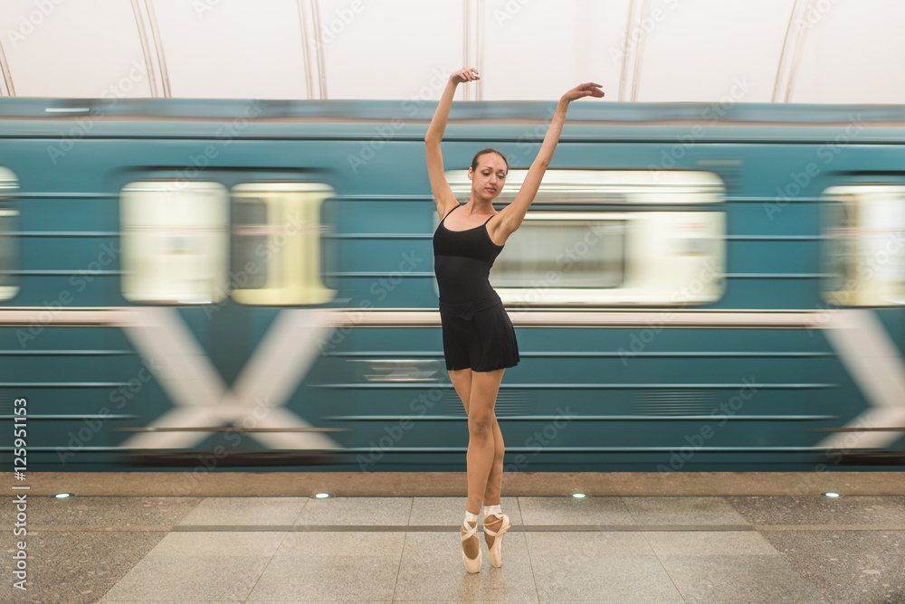 Fototapeta premium Ballerina in subway with moving train on the background