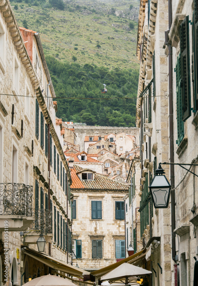 The scenic cable car that carries people to the top of Mount Srd in Dubrovnik, Croatia, is visible through the buildings of the old town.