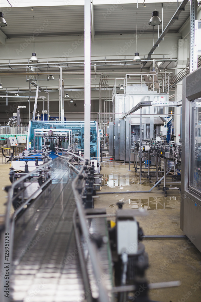 Obraz premium Industrial interiors. Robotic factory line for processing and quality control of pure spring water bottled into canisters.