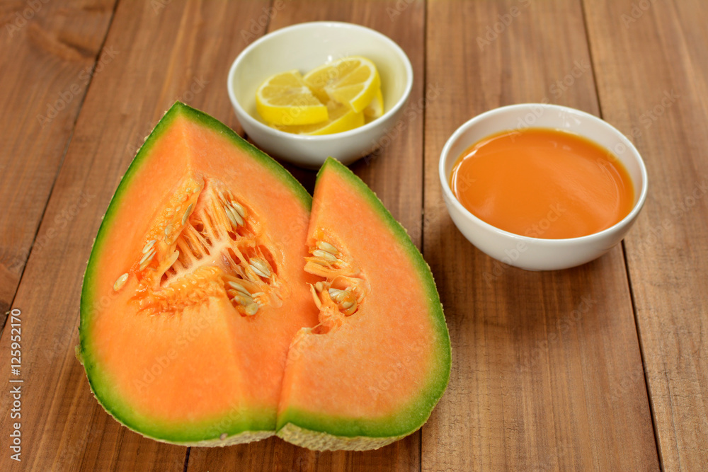 Cantaloupe fruit, lemon and juice on wooden background. Cantaloupe fruit, lemon and juice on wooden background.