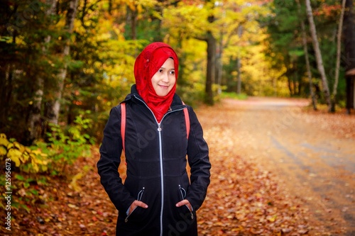 Muslim woman in North America during autumn with colorful maple leaf as background