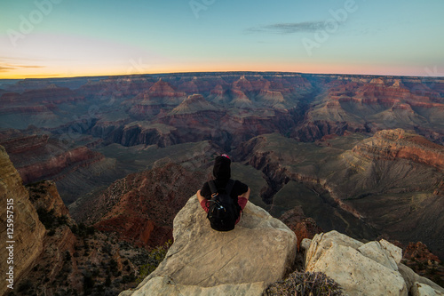 A person observing an overlook from the southern rim of Grand Canyon National Park, AZ, USA during dusk hours.
