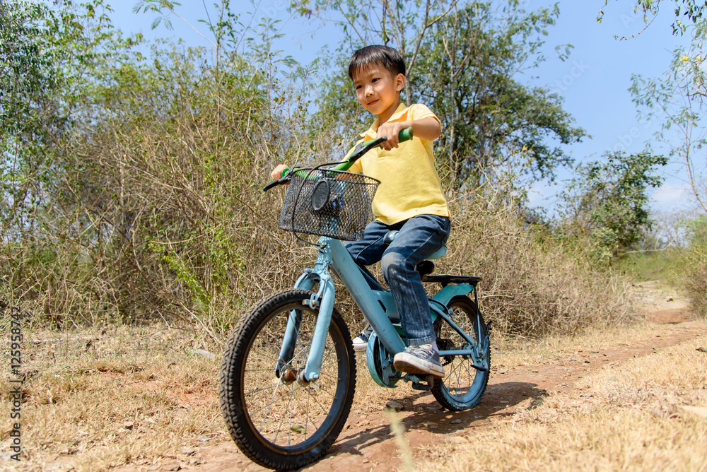 Little boy ride bicycle on the rock road. Little boy ride bicycle on the rock road.