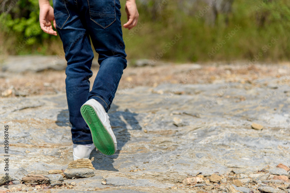 Obraz premium Boy walking on the rocky land.