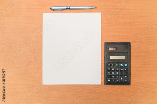 Calculadora con pluma ejecutiva en escritorio de madera photo