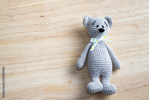 amigurumi doll bear on a wooden table with copy space