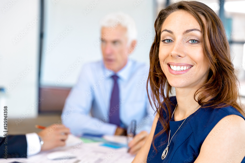 Obraz premium Young businesswoman sitting at desk and working