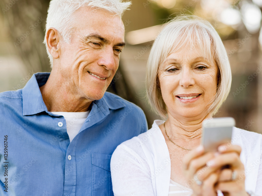 Happy senior couple looking at smartphone Happy senior couple looking at smartphone