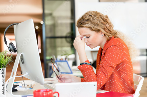 Young woman in office tired photo