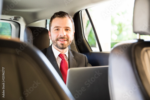 Hispanic man working while riding a car © AntonioDiaz