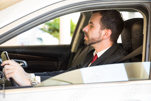 Man in a suit driving a car