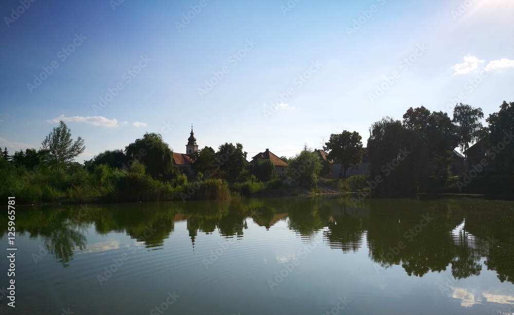 Village and sky reflection in small lake