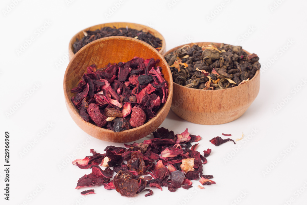 Dry tea in wooden plates, on white background. Leaves of red, green and black tea. Macro photo. Dry tea in wooden plates, on white background. Leaves of red, green and black tea. Macro photo.