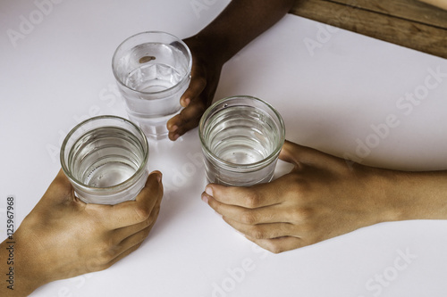 mains d'enfants tenant des verres d'eau 