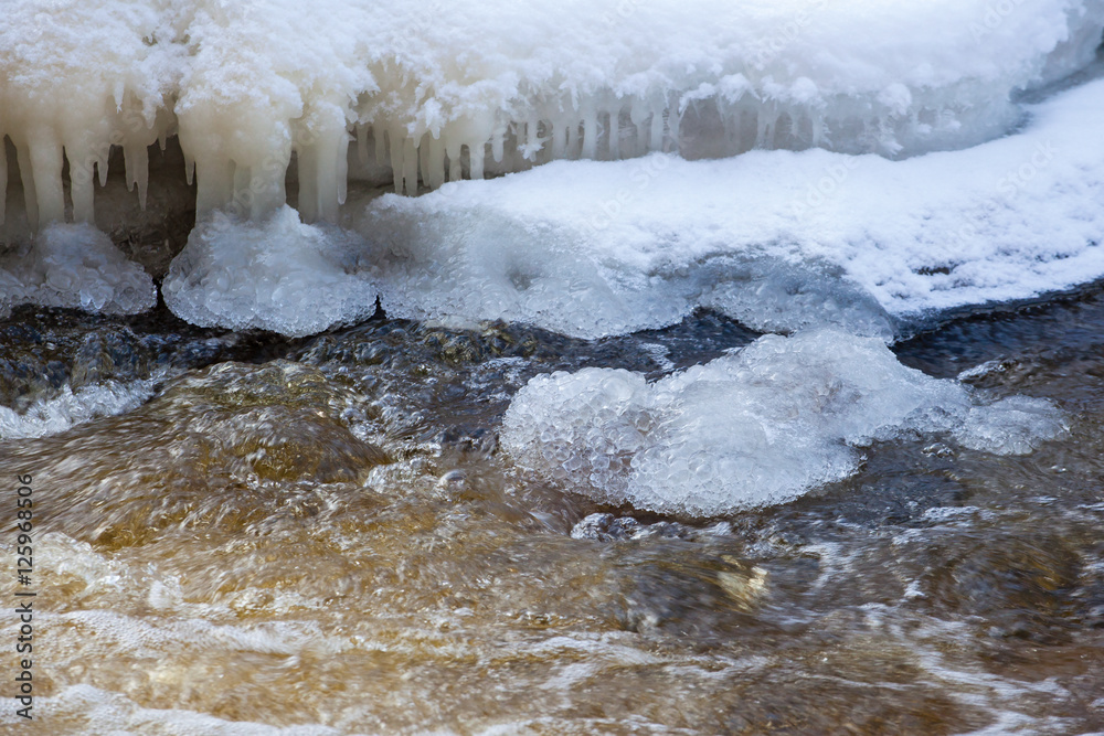 Water that flows in the river with icicles Water that flows in the river with icicles