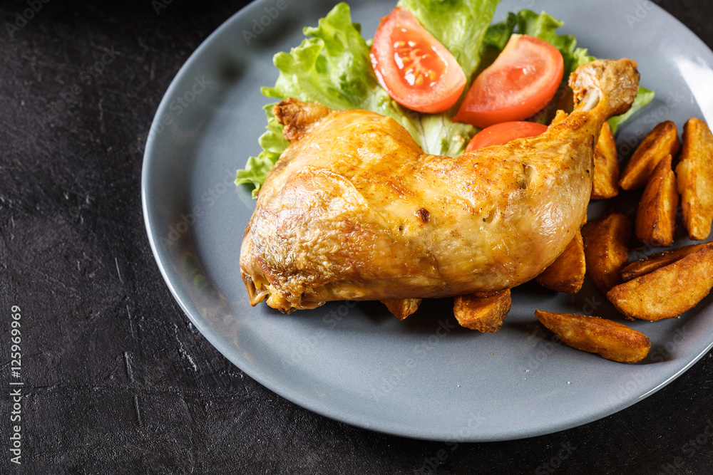 Roasted chicken legs with potato wedges and tomatoes Roasted chicken legs with potato wedges and tomatoes