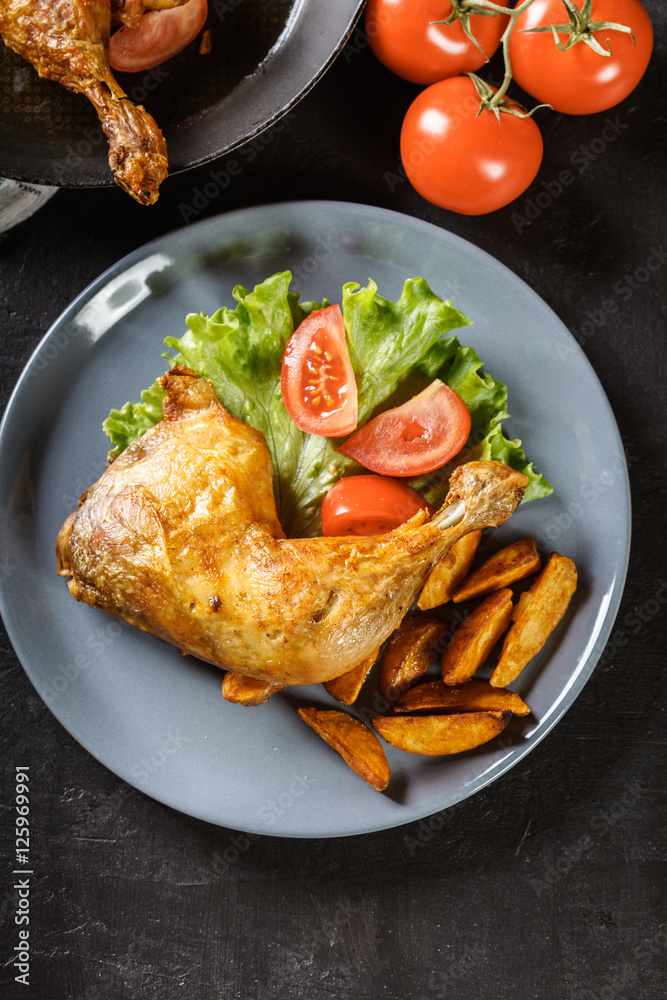 Roasted chicken legs with potato wedges and tomatoes Roasted chicken legs with potato wedges and tomatoes