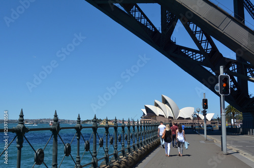 People walks under Sydney Harbour Bridge towards Sydney Opera Ho