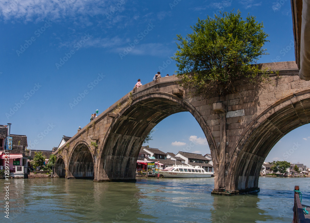 Fototapeta premium Tourists see the sights of ancient water town