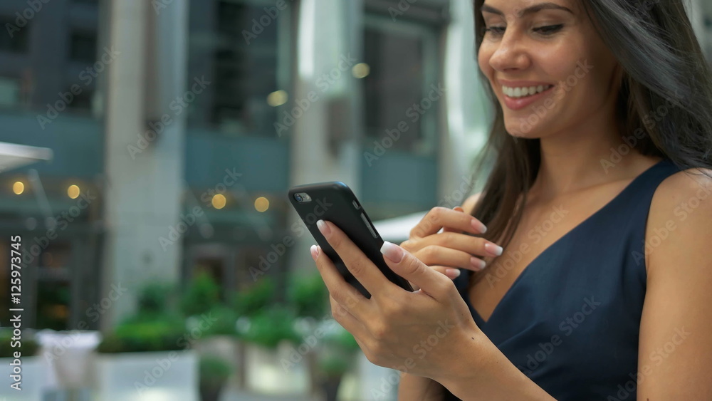 Attractive business woman commuter using smartphone walking in city Attractive business woman commuter using smartphone walking in city