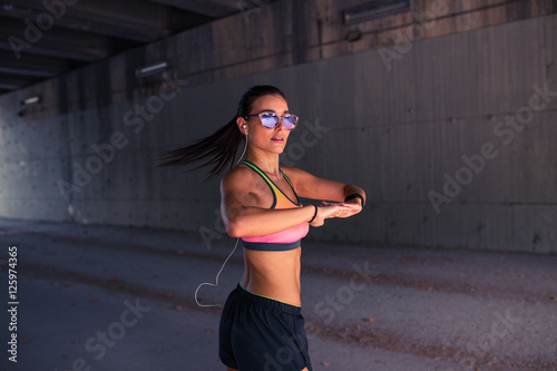 Fit woman runner stretching outdoors © Manuel