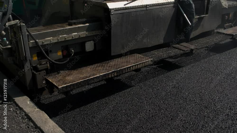 Black asphalt surface. Vehicle with control panel. Construct a highway. Building company purchased new equipment. Black asphalt surface. Vehicle with control panel. Construct a highway. Building company purchased new equipment.