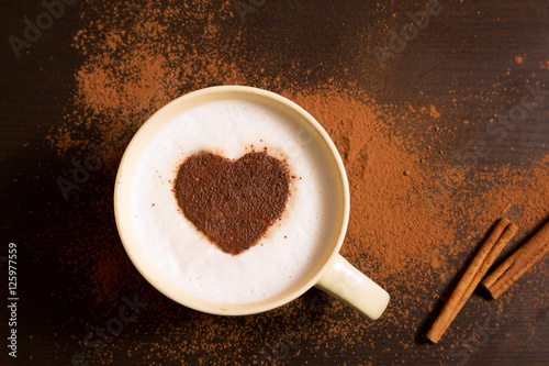 Cup of coffee with heart pattern of cinnamon