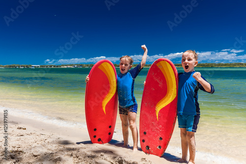 Photography Young surfer brothers have fun on beach learning to surf